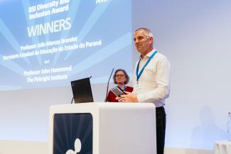 John Hammond stood behind a lectern holding an award
